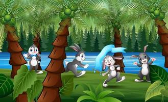 dessin animé de lapins heureux jouant dans une forêt vecteur