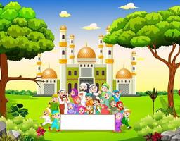la grande famille heureuse tient la bannière vierge près de la mosquée vecteur