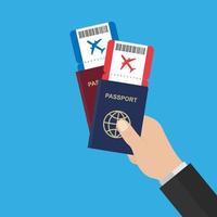 la main tient des passeports et des billets d'avion rouges et bleus. vecteur