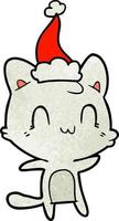 dessin animé texturé d'un chat heureux portant un bonnet de noel vecteur