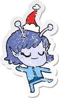 fille extraterrestre souriante autocollant en détresse dessin animé d'un bonnet de noel vecteur