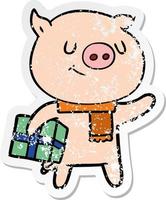 autocollant en détresse d'un cochon de dessin animé heureux avec un cadeau de noël vecteur