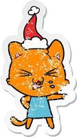 dessin animé autocollant en détresse d'un chat sifflant portant un bonnet de noel vecteur