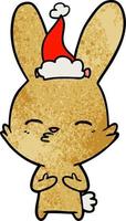 dessin animé texturé de lapin curieux d'un bonnet de noel vecteur