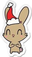 dessin animé mignon autocollant d'un lapin portant un bonnet de noel vecteur