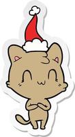 caricature d'autocollant d'un chat heureux portant un bonnet de noel vecteur