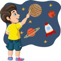 mignon petit garçon peignant une fusée, des étoiles et des planètes sur le mur vecteur