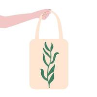 main tenant un sac fourre-tout en toile écologique avec feuille verte. sacs à provisions faits à la main. vecteur