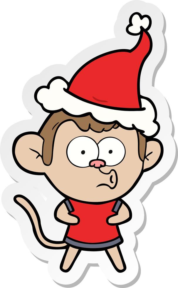 desenho de adesivo de um macaco surpreso usando chapéu de papai noel vetor