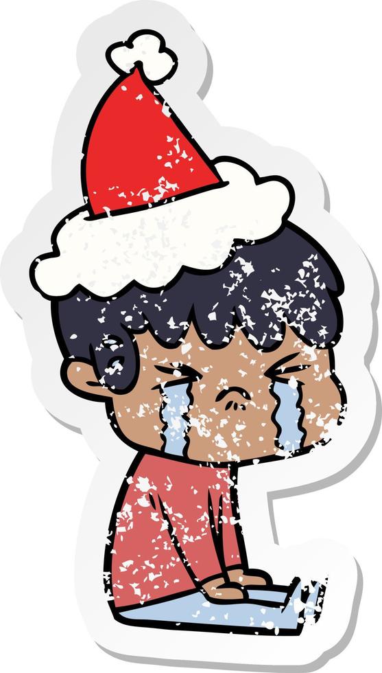 desenho de adesivo angustiado de um menino chorando usando chapéu de papai noel vetor