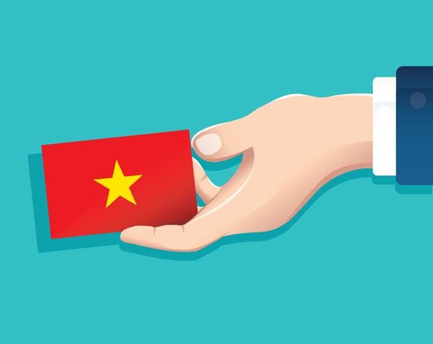 mão segurando o cartão de bandeira do Vietnã com fundo azul vetor