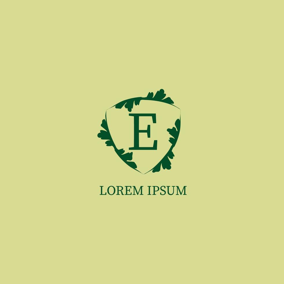 letra e modelo de design de logotipo alfabético isolado na cor bege verde. ilustração de sinal de escudo floral decorativo. guarda da natureza, conceito de logotipo de segurança. vetor