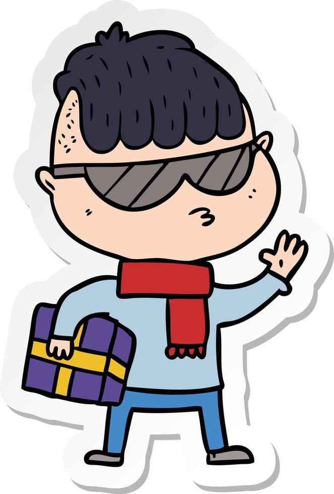 adesivo de um menino de desenho animado usando óculos escuros carregando presente de natal vetor
