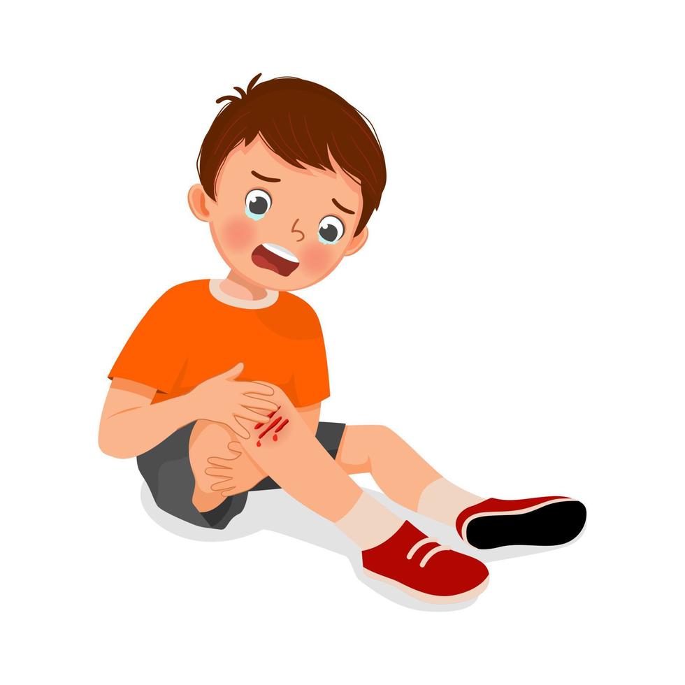 menino triste tem uma lesão no joelho chorando segurando sua perna sangrando com hematomas depois de cair vetor