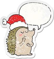 ouriço de desenho animado usando chapéu de natal e adesivo angustiado de bolha de fala vetor