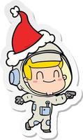 desenho de adesivo feliz de um homem astronauta usando chapéu de papai noel vetor