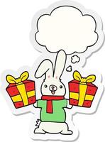 coelho de desenho animado com presentes de natal e balão de pensamento como um adesivo impresso vetor