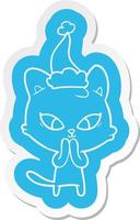 adesivo bonito dos desenhos animados de um gato usando chapéu de papai noel vetor