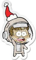 desenho de adesivo angustiado de um astronauta surpreso usando chapéu de papai noel vetor