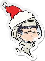 desenho de adesivo angustiado de um astronauta estressado usando chapéu de papai noel vetor