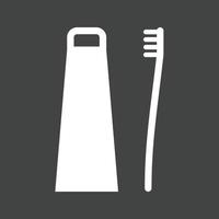ícone invertido de glifo de escova e pasta de dentes vetor