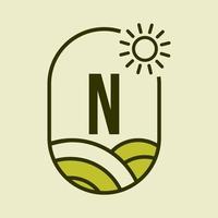 modelo de emblema do logotipo da agricultura da letra n. fazenda agrícola, agronegócio, sinal de fazenda ecológica com sol e símbolo de campo agrícola vetor