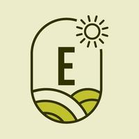 modelo de emblema do logotipo da agricultura da letra e. fazenda agrícola, agronegócio, sinal de fazenda ecológica com sol e símbolo de campo agrícola vetor