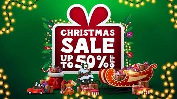 promoção de natal, desconto de até 50, banner de desconto verde com grande desenho animado com grande oferta decorada com galhos de árvores de natal, doces, guirlandas e presentes vetor