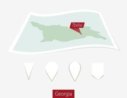 curvado papel mapa do geórgia com capital tbilisi em cinzento fundo. quatro diferente mapa PIN definir. vetor