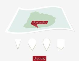 curvado papel mapa do Uruguai com capital montevideo em cinzento fundo. quatro diferente mapa PIN definir. vetor