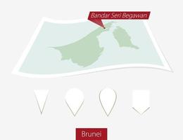 curvado papel mapa do brunei com capital Bandar seri Begawan em cinzento fundo. quatro diferente mapa PIN definir. vetor