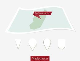 curvado papel mapa do Madagáscar com capital antananarivo em cinzento fundo. quatro diferente mapa PIN definir. vetor