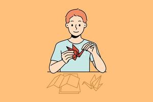 sorridente pequeno Garoto sentar às escrivaninha faço origami. feliz criança apreciar passatempo atividade fazer pássaros a partir de papel. vetor ilustração.