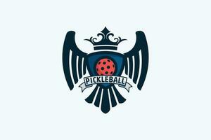 heráldico pickleball logotipo com uma combinação do uma bola, Águia asas e cauda, fita, e coroa dentro heráldico estilo. vetor