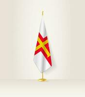 Guernsey bandeira em uma bandeira ficar em pé. vetor