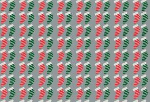 festivo verde e vermelho Natal meias padronizar em cinzento fundo vetor