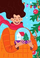 mulher sorridente segurando um globo de neve com a casa e a árvore de natal dentro vetor