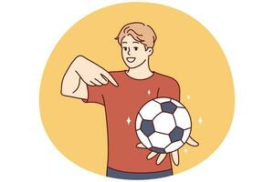 jovem homem detém futebol bola e pontos dedo às isto, oferta para jogar futebol. vetor imagem