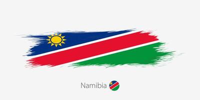 bandeira do namíbia, grunge abstrato escova acidente vascular encefálico em cinzento fundo. vetor
