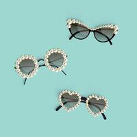 conjunto do realista elegante oculos de sol do diferente forma decorado com pérolas sobre turquesa fundo. vetor ilustração