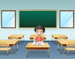 Um menino dentro de uma sala de aula com um tabuleiro vazio na parte de trás