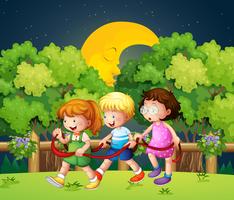 Três crianças andando ao ar livre no meio da noite vetor