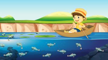 Um menino em um barco no rio vetor