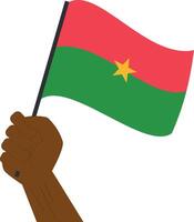 mão segurando e levantando a nacional bandeira do burkina faso vetor