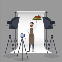blogueiro de culinária. um homem com um avental de cozinha segura um frango frito em uma bandeja. câmera em um tripé, softbox. conceito de blog ou vlog culinário. vetor. vetor