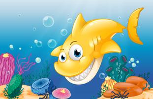 Um tubarão amarelo sorrindo sob o mar vetor