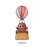 mascote de ovo de chocolate montando um balão de ar quente vetor