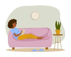mulher grávida com uma barriga grande senta-se no sofá e lê um livro. projeto plano. ilustração vetorial. vetor