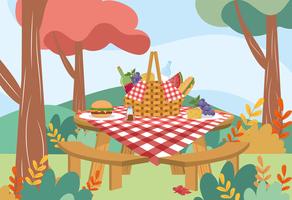 Cesta de piquenique com toalha de mesa e comida na mesa no parque vetor