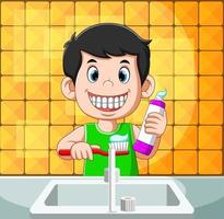 menino está sorrindo e escovando o com a pasta de dente vetor